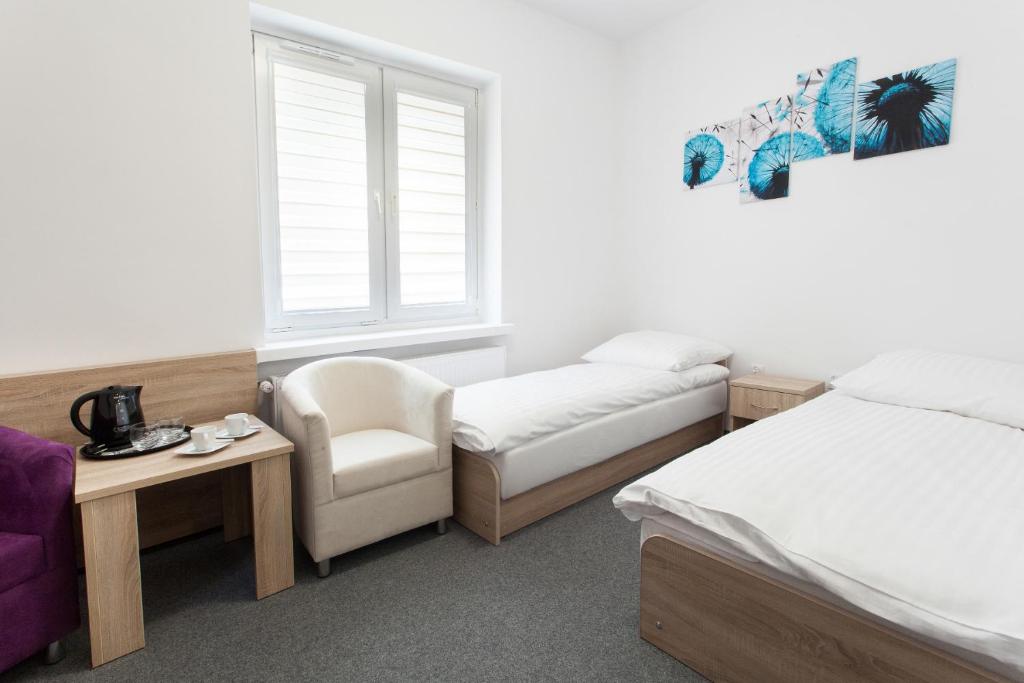 科宁Dom Studenta Nr 1 ANS w Koninie的客房设有两张床、一把椅子和窗户。