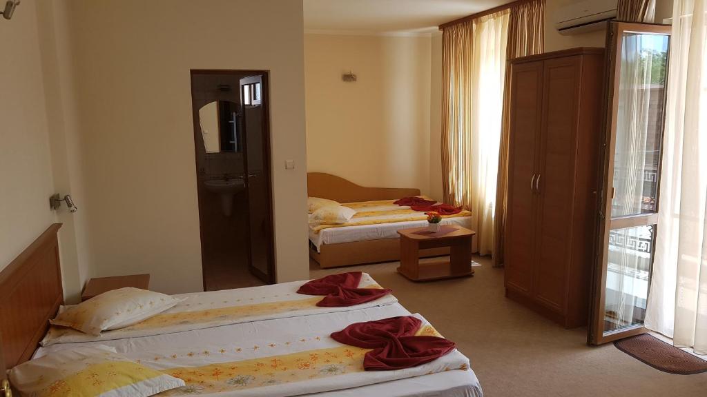 阿赫洛伊Guest House Markovi Aheloy的酒店客房,设有两张床和镜子