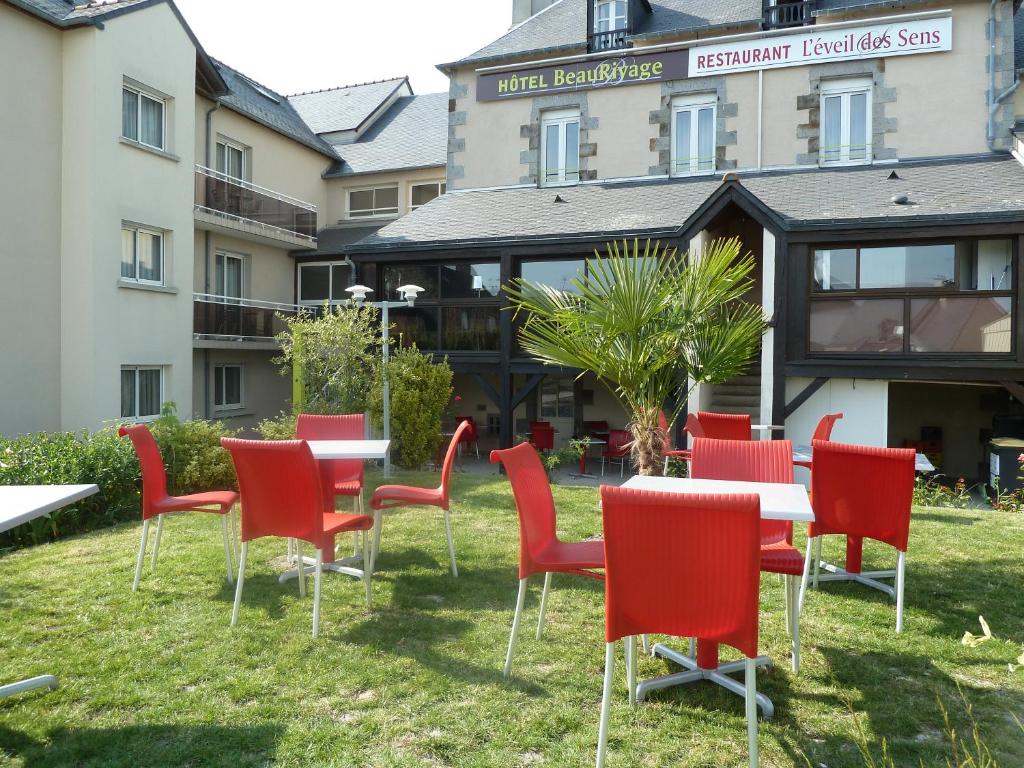 滨海勒维维耶博里瓦奇酒店的一组红色的桌椅,位于一座建筑前面