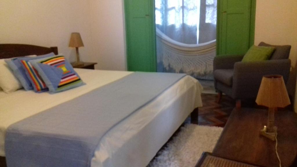 萨尔瓦多Pousada Baluarte的卧室配有床、椅子和窗户。