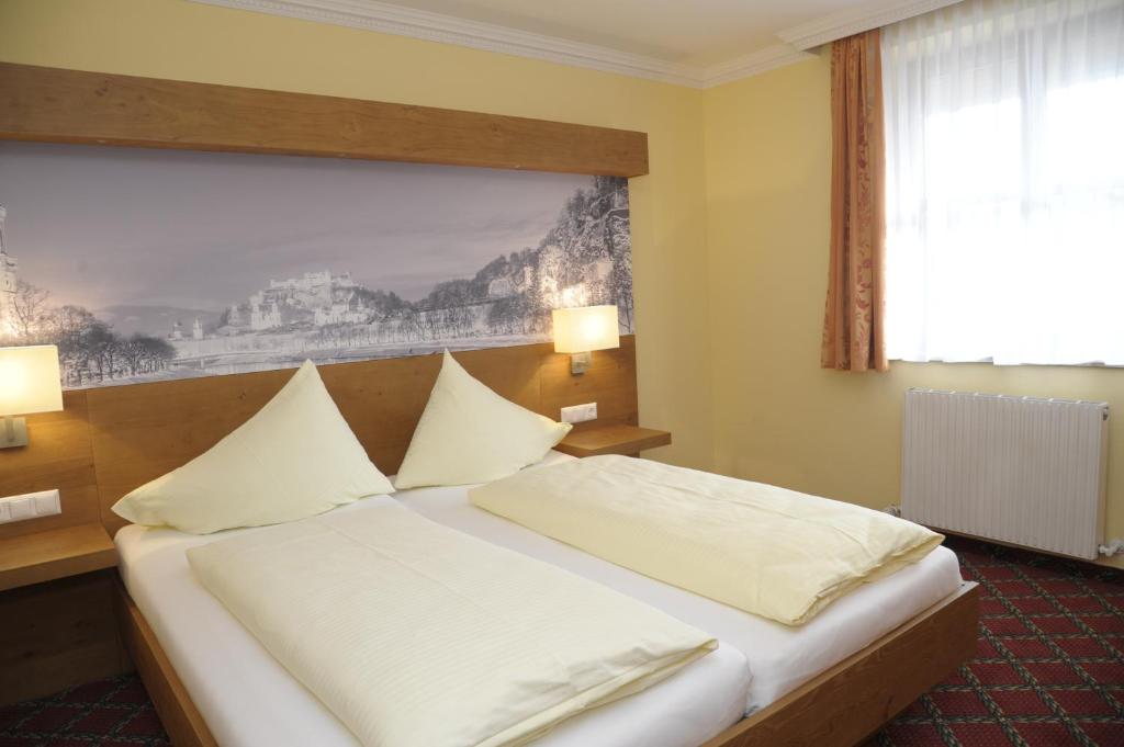 瓦兹加斯赫夫卡木尔酒店的配有白色枕头的床的酒店客房