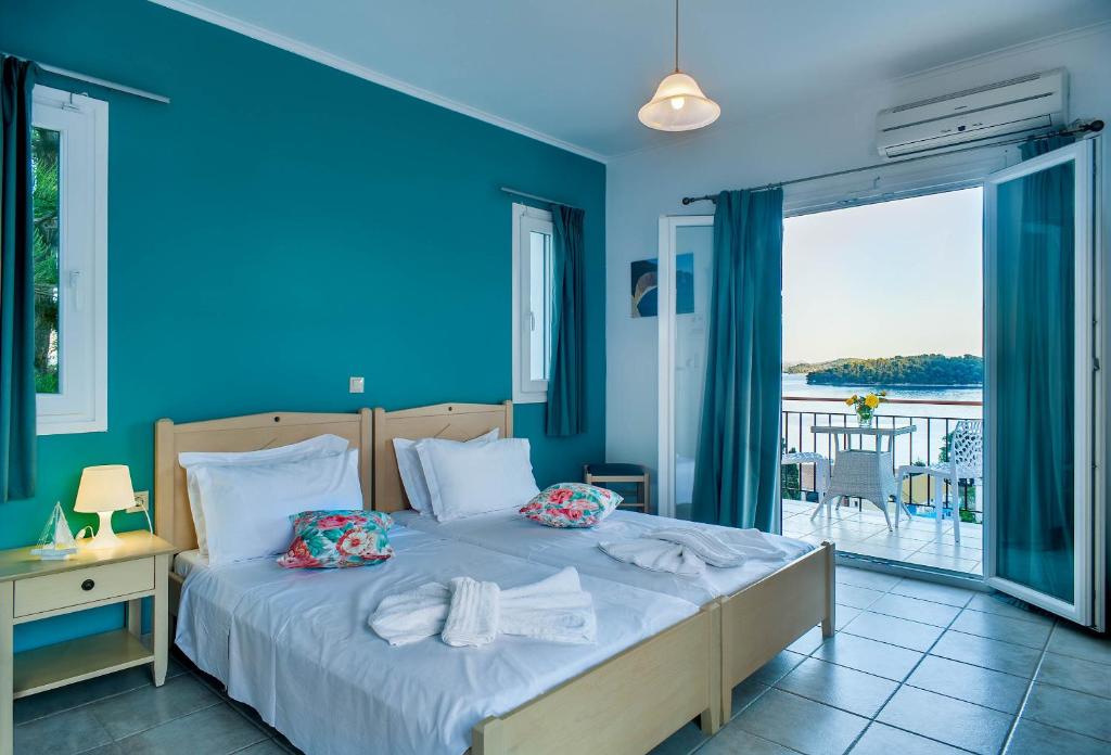 奈德里圣拉扎罗酒店的一间卧室设有一张蓝色墙壁的床和一个阳台。