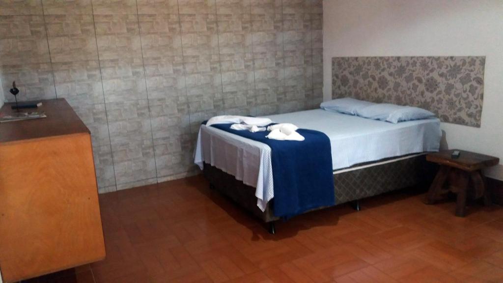 沙帕达-杜斯吉马朗伊斯Pousada Portal的一间卧室配有一张带毛巾的桌子。