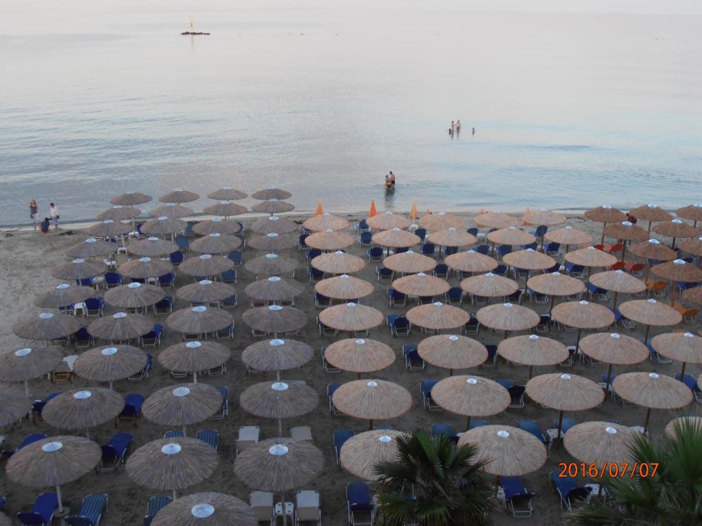 帕拉利亚卡泰里尼斯奥斯卡酒店的海滩上的一把遮阳伞和椅子