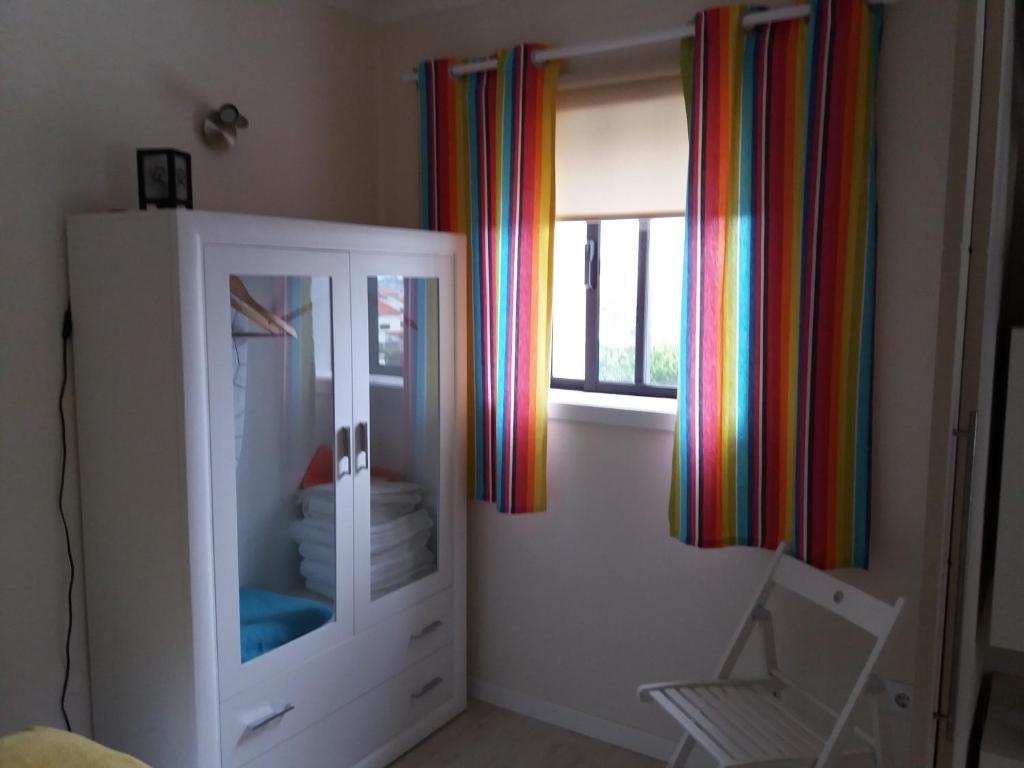 普拉亚达巴拉Sossego Da Ria的一间设有橱柜和彩虹窗帘的窗户的客房