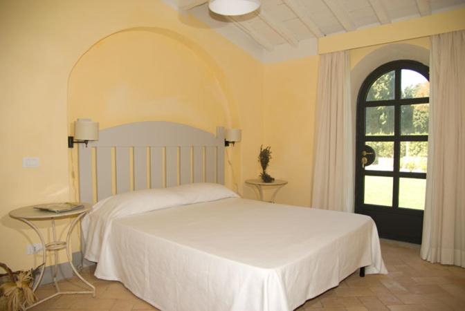 波尔图·埃尔科莱Fonte del Lupo的卧室配有白色的床和窗户。