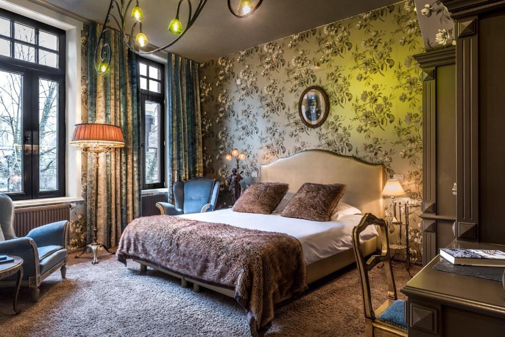 伊普尔主街酒店的壁纸客房内的一间卧室配有一张床