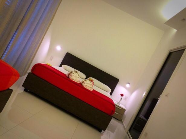 玛格丽塔萨沃亚B&B Sabin Ross的一间在房间内配有红色和白色床的卧室
