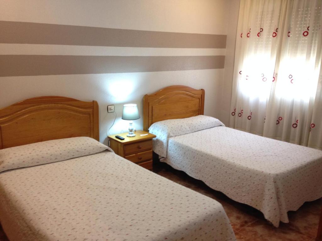 布利亚斯弗利珀膳食公寓酒店的一间卧室设有两张床和一张桌子上的台灯。