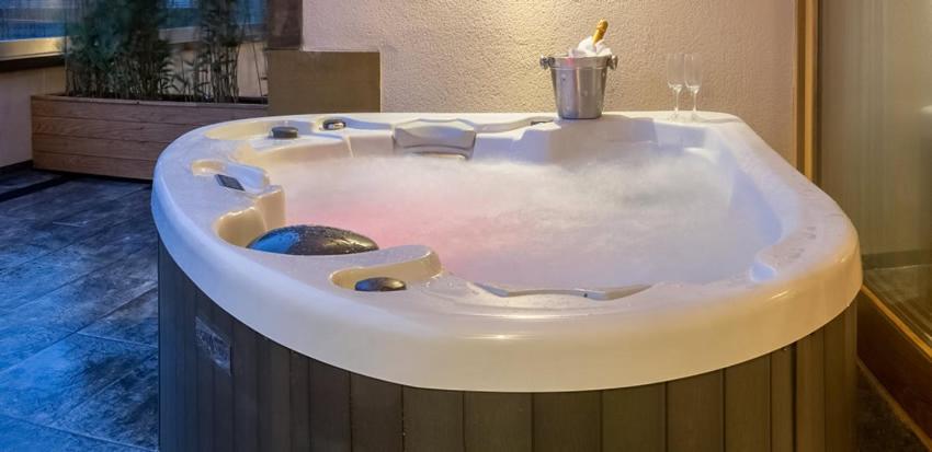 温德米尔Applegarth Villa Hotel & Restaurant (Adult Only)的一个带蜡烛的客房内的按摩浴缸