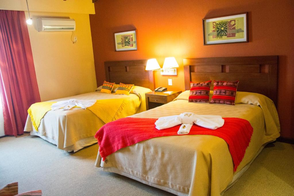 罗萨里奥德拉弗龙特拉罗萨里奥弗龙特拉豪生国际酒店的酒店客房设有两张床,并备有浴袍。