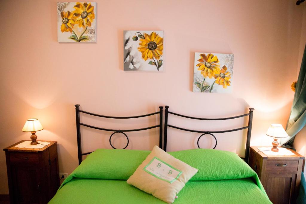 巴尼奥雷焦拉洛盖塔住宿加早餐旅馆的一间卧室配有一张绿色的床,墙上挂有绘画作品