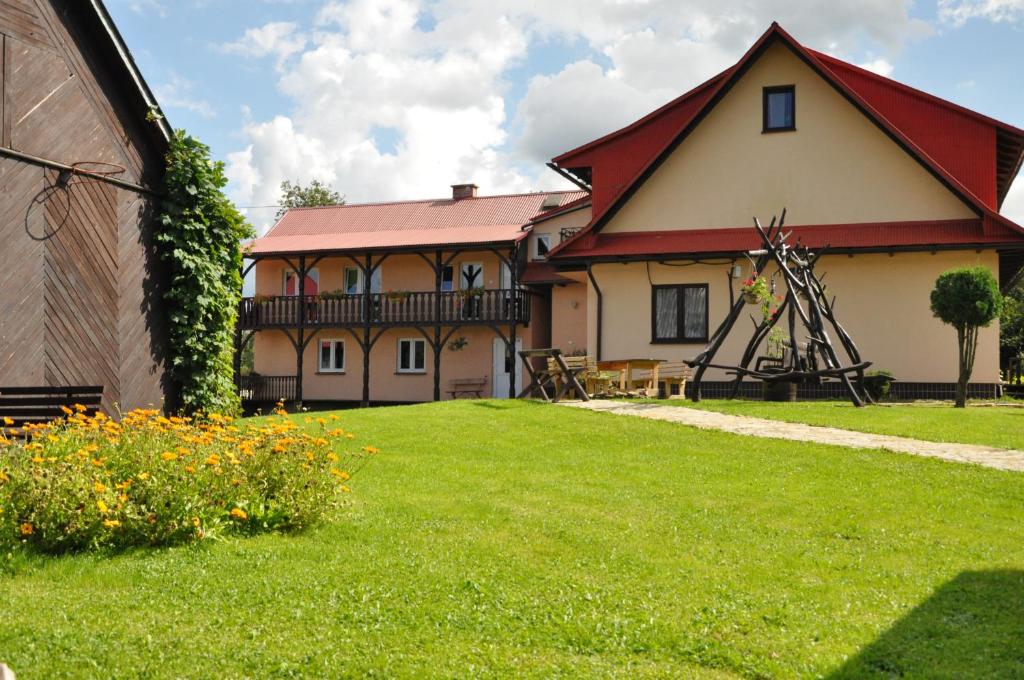下乌斯奇基Nad Krolówką的一座有红色屋顶和草地庭院的房子