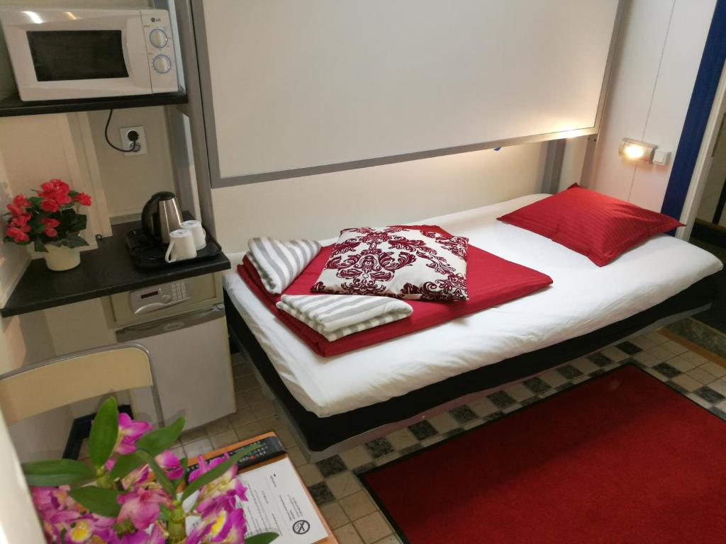 斯德哥尔摩斯德哥尔摩经典经济旅舍的小房间的小床,配有红色枕头