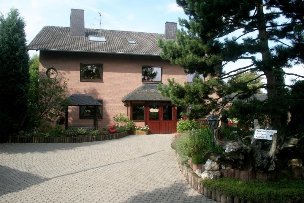 施莱登Ferienwohnung-Geschwind的砖车道上一扇红门的房子
