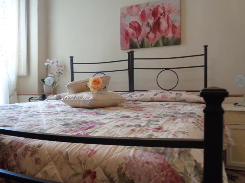 卢卡茶花宾馆的一间卧室配有一张带花卉床罩的床