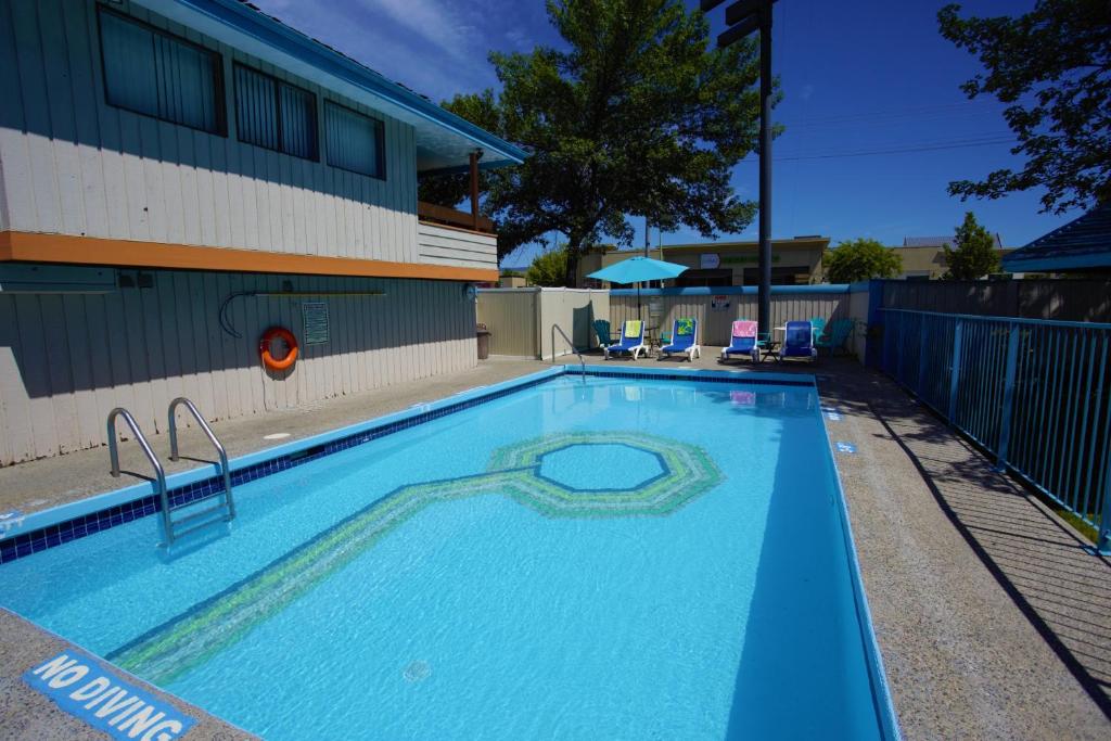 基洛纳休憩套房酒店的一座大型蓝色游泳池,位于大楼旁边