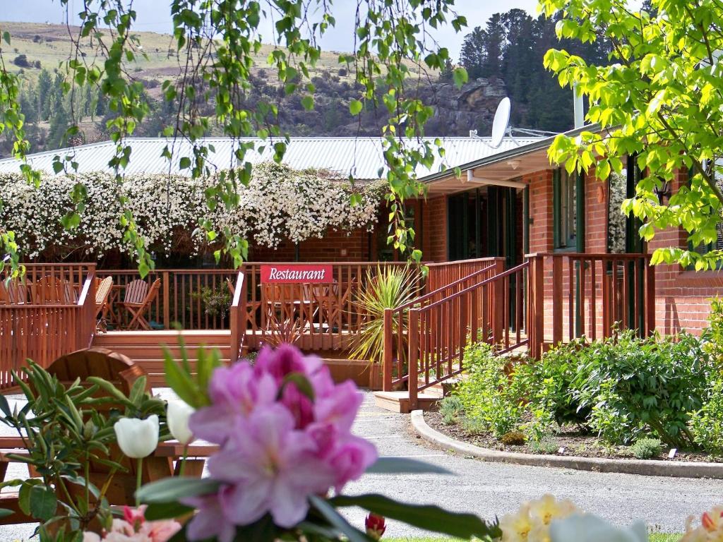 Roxburgh罗克斯堡湖旅舍的一座房子前面有甲板和鲜花
