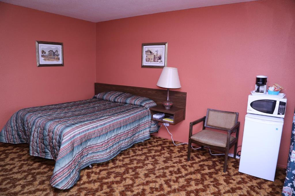 艾伯尼港木屋房车和露营汽车旅馆的配有一张床和一把椅子的酒店客房