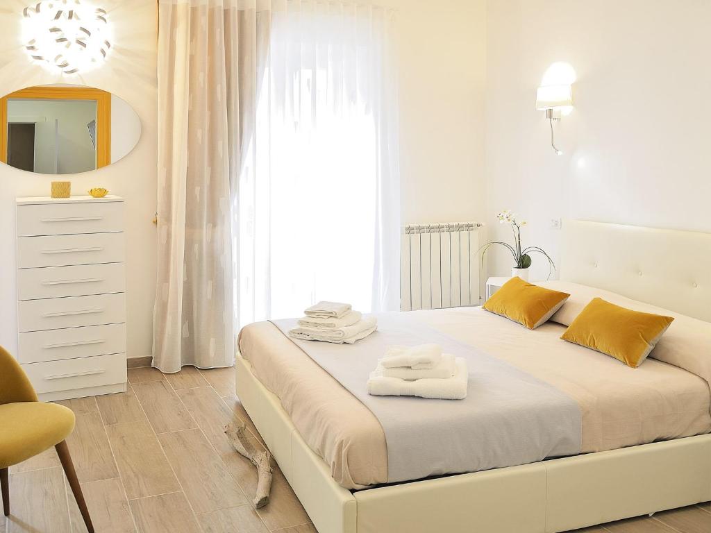 塔兰托Duca70 "Suite Home"的白色卧室,配有带毛巾的床