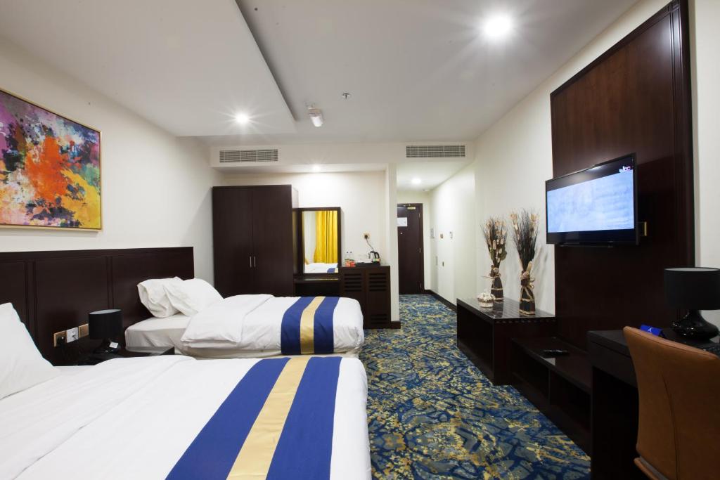 马斯喀特阿马拉酒店的酒店客房设有两张床和一台平面电视。