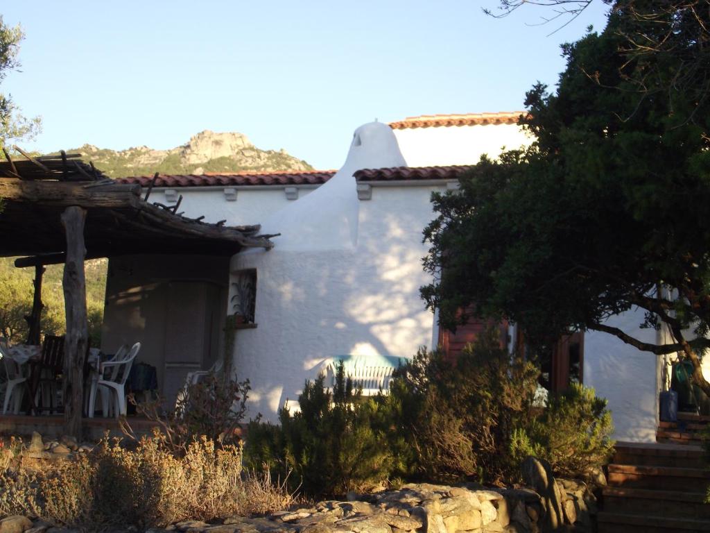 库尼亚纳Casa Marcella Cugnana-Portisco的白色的房子,配有桌子和椅子