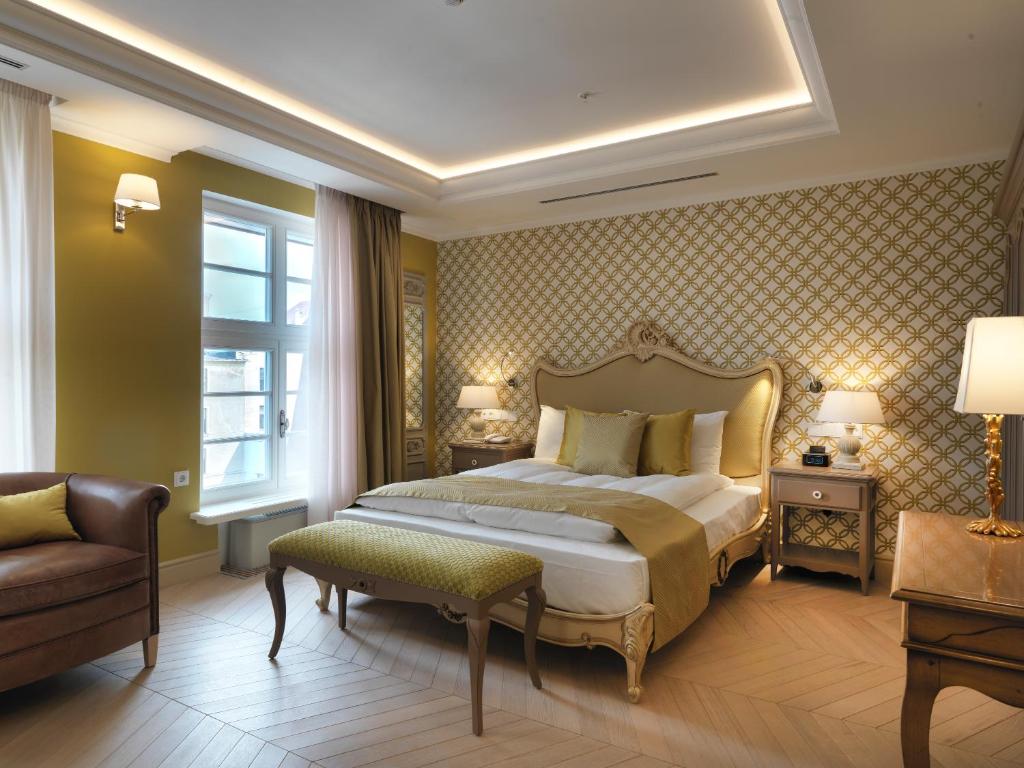 里加瑞莱斯骑士酒店的卧室配有床、椅子和窗户。