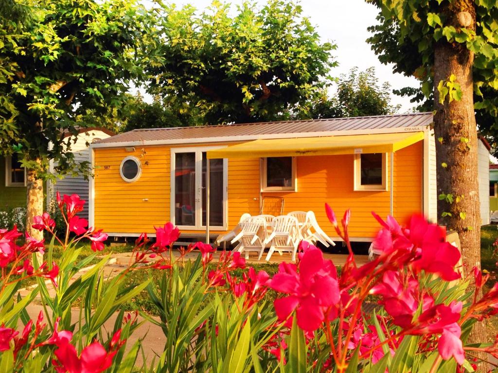 佩斯基耶拉德加达加达假日公园的前面有白色长凳的小黄色房子