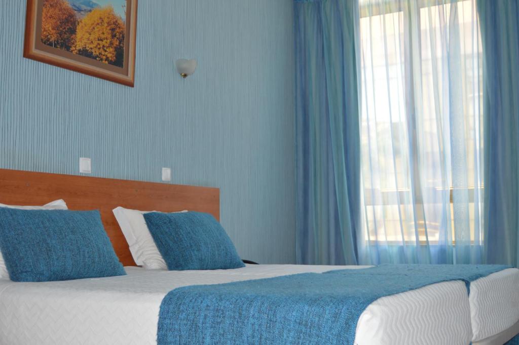 比索达雷加因佩里奥酒店的一间卧室配有一张蓝色墙壁的床和一扇窗户