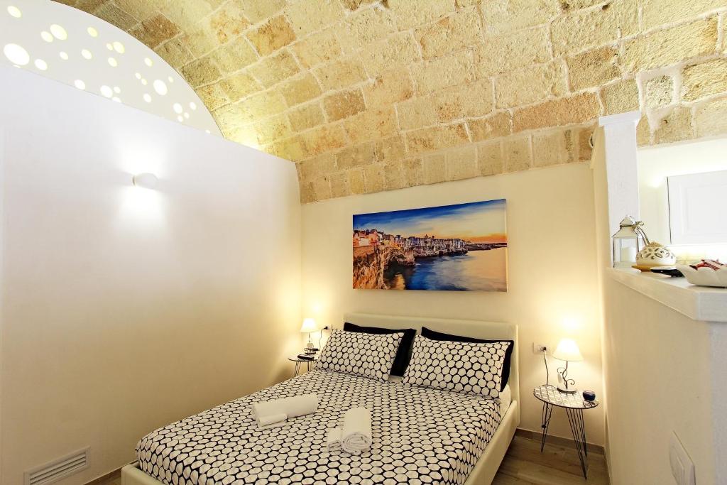 滨海波利尼亚诺Il Viandante的一间卧室设有一张床和砖墙