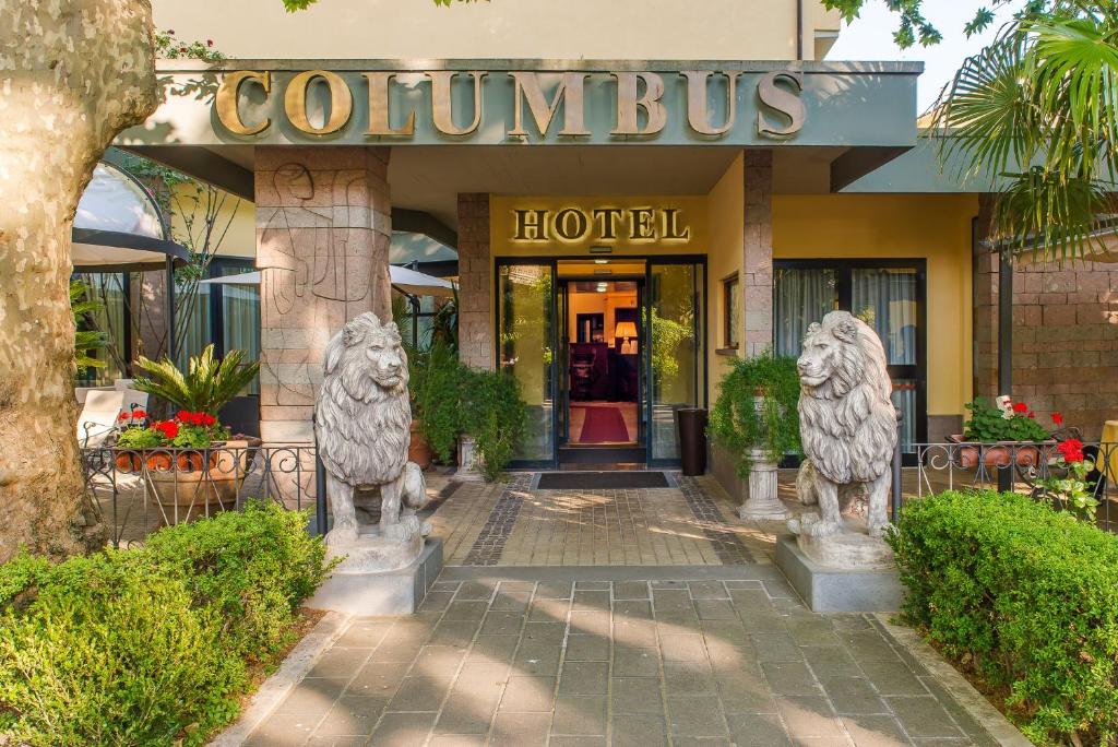 博尔塞纳Hotel Columbus sul Lago的前面有两座狮子雕像的酒店
