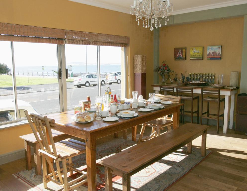 开普敦海豚宾馆的一间带木桌和椅子的用餐室和一间厨房