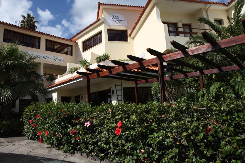 卡尼索维拉文图拉酒店的前面有栅栏和鲜花的建筑