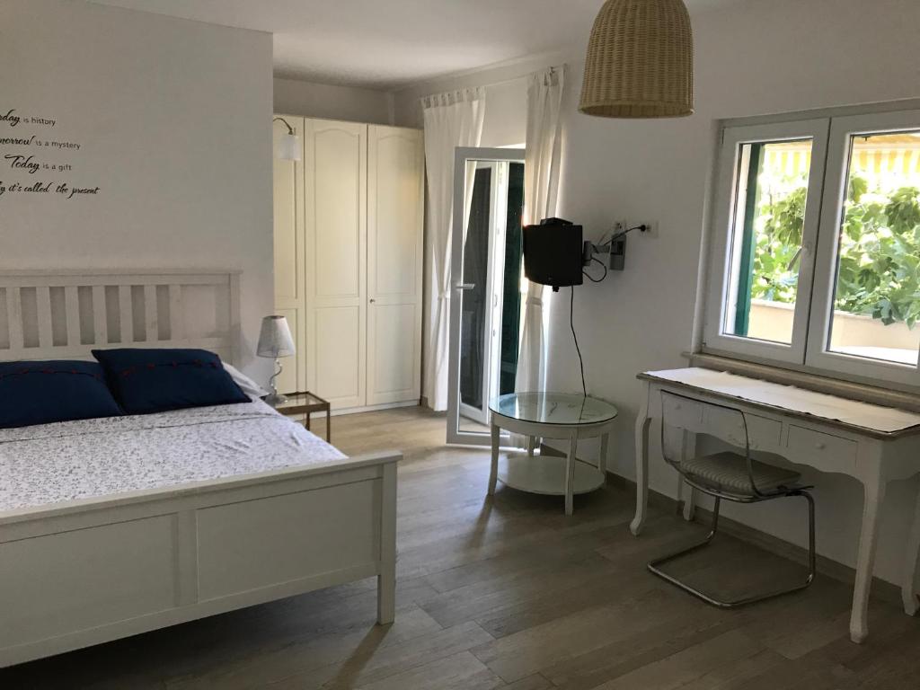 穆泰尔岛Guesthouse Davorka Bijelić的一间卧室配有一张床、一张书桌和一个窗户。