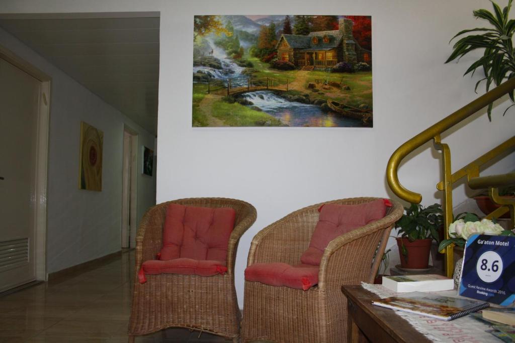 纳哈里亚嘉腾汽车旅馆的墙上画画的房间里,有两把椅子