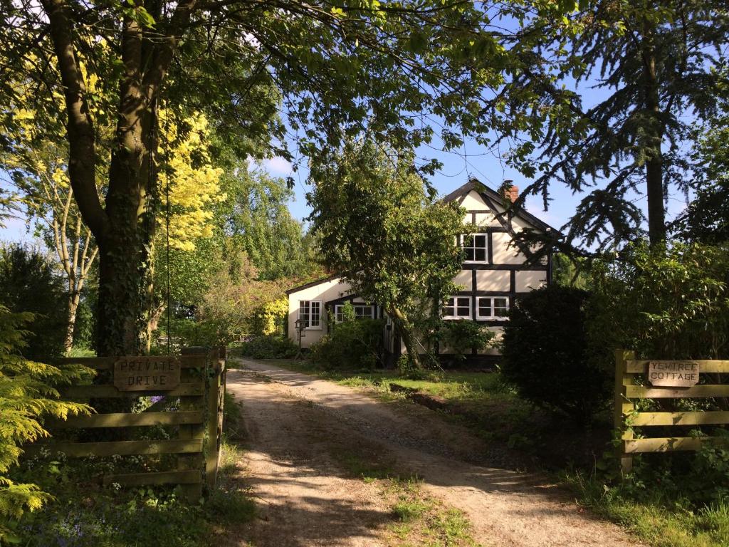 莱明斯特Yew Tree Cottage的前面有栅栏的白色房子