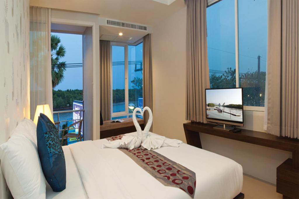 甲米镇甲米望江楼酒店的一间卧室设有一张床、一台电视和窗户。