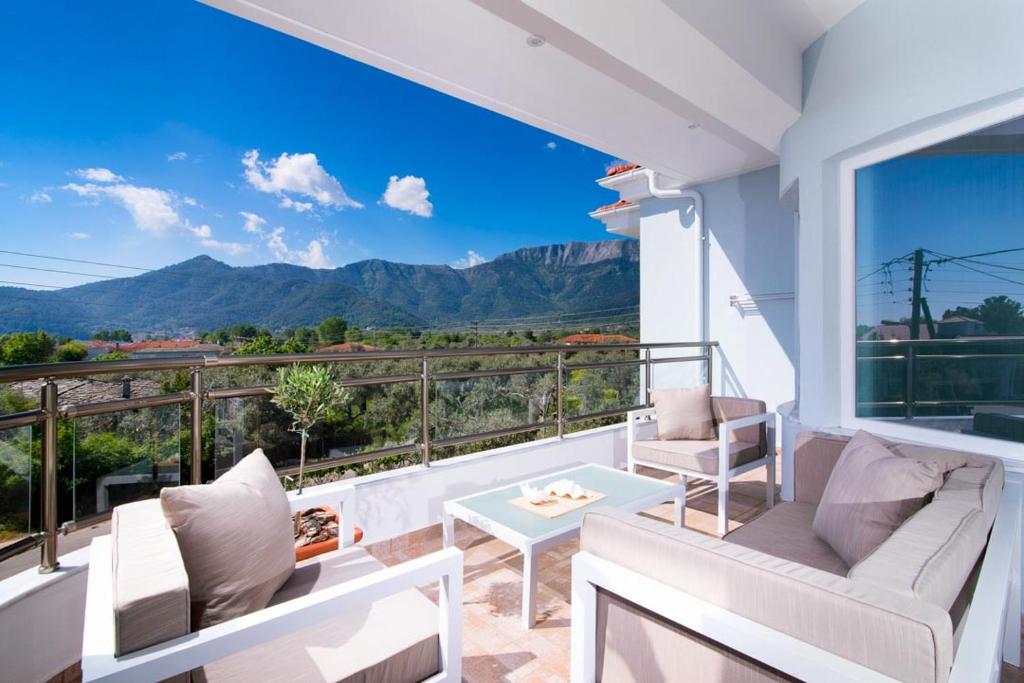 克里斯阿穆迪亚Olive Garden Villas and Apartments的山景阳台,配有白色家具。