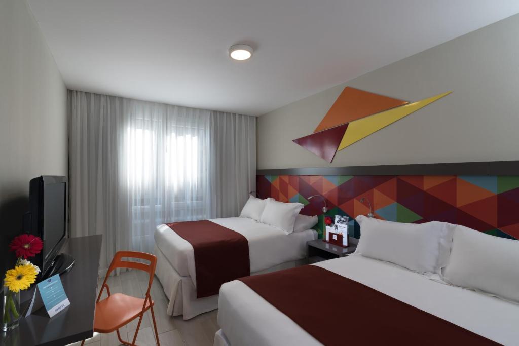 圣多明各霍德尔帕诺夫广场酒店的酒店客房设有两张床和彩色墙壁。