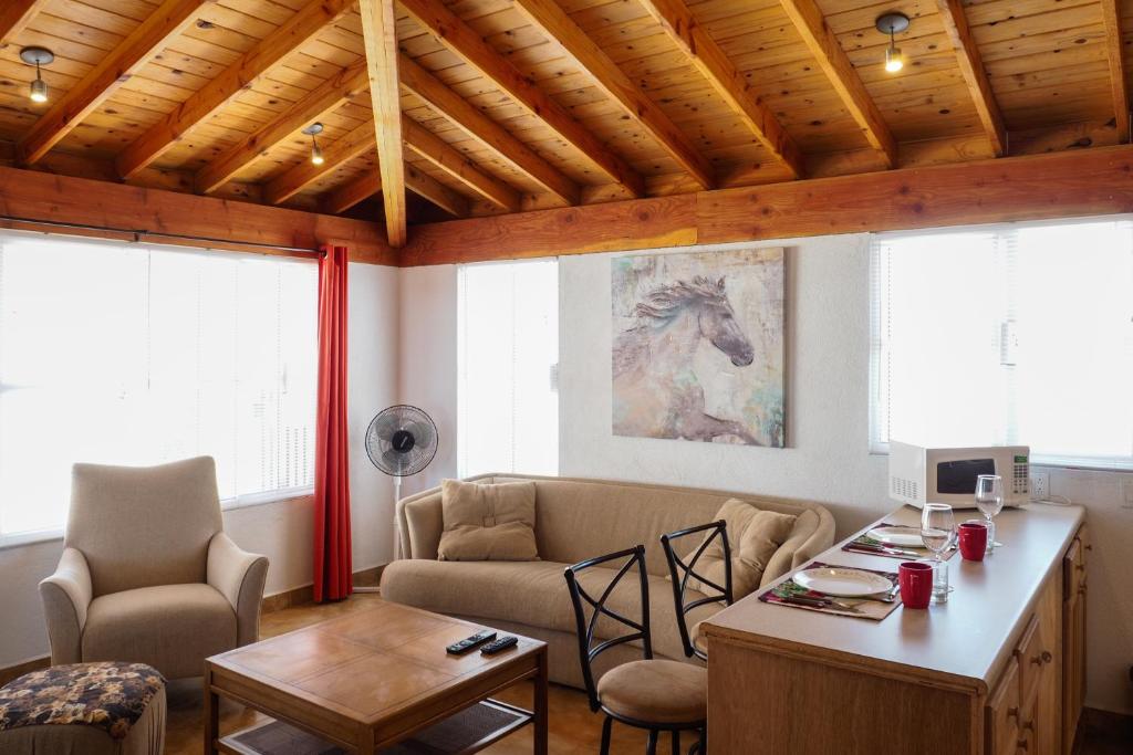 瓜达鲁佩镇Little Nest en Rancho El Rossinyol的客厅配有沙发和桌子
