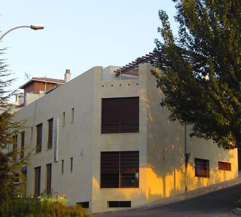 阿尔卡拉拉雷亚尔拉韦德格拉纳达公寓的一座白色的大建筑,窗户在建筑的一侧