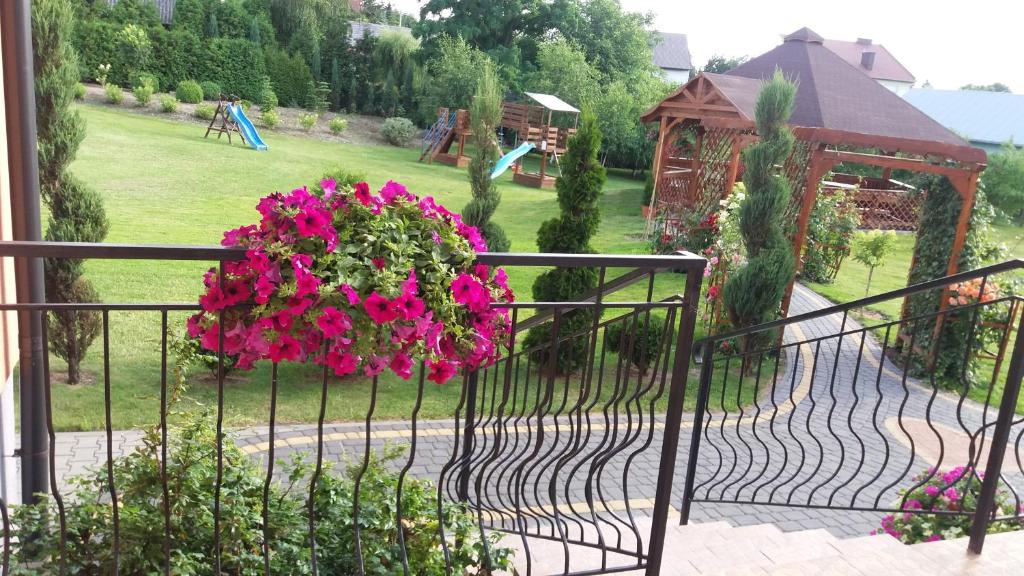 Stopnica鲁瓦维奇餐厅酒店的铁艺围栏,挂着一篮粉红色的花