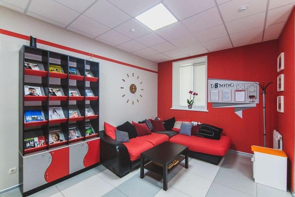 科夫罗夫Domino Hostel的客厅设有红色的墙壁和红色的沙发