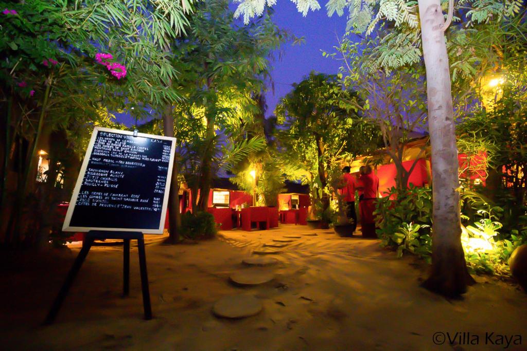 瓦加杜古Villa Kaya Lodge的夜间花园中的一个标志