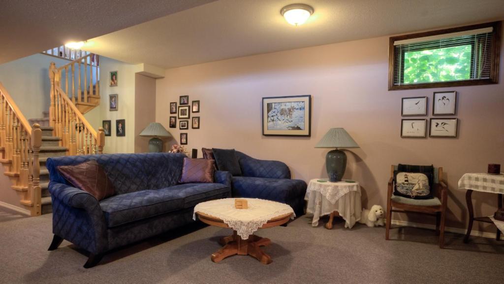 克利尔沃特Hummingbird Bed and Breakfast的客厅配有蓝色的沙发和桌子