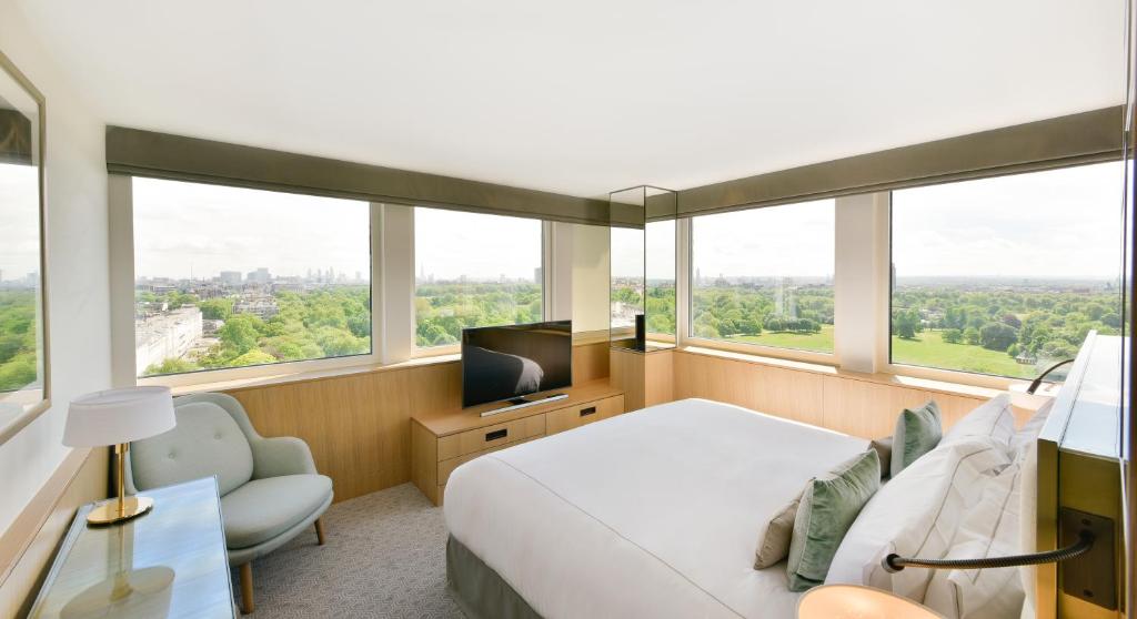 伦敦伦敦皇家兰开斯特酒店的一间卧室设有一张床、一台电视和窗户。