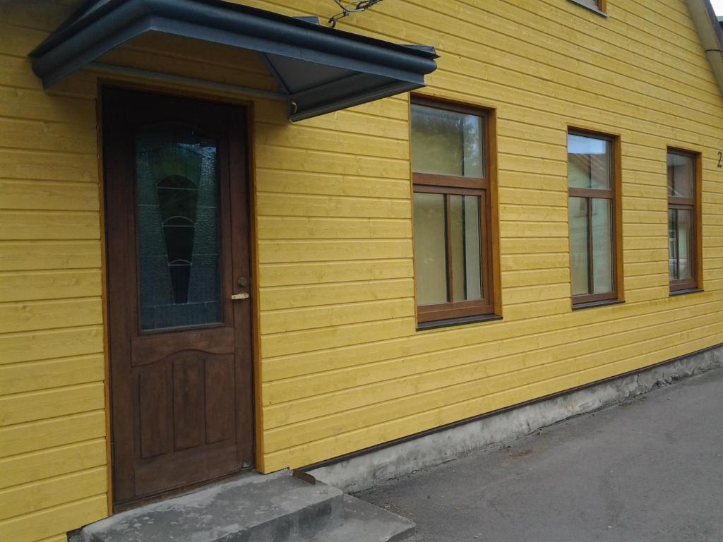 派尔努Jaani 2-1 Apartment的黄色的房子,设有木门和窗户