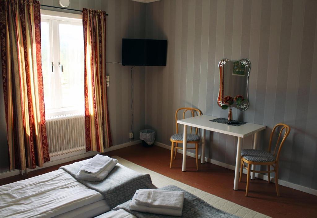 AmmarnäsAmmarnäsgården Fjällhotell och Vandrarhem的一间卧室配有一张床和一张带镜子的桌子
