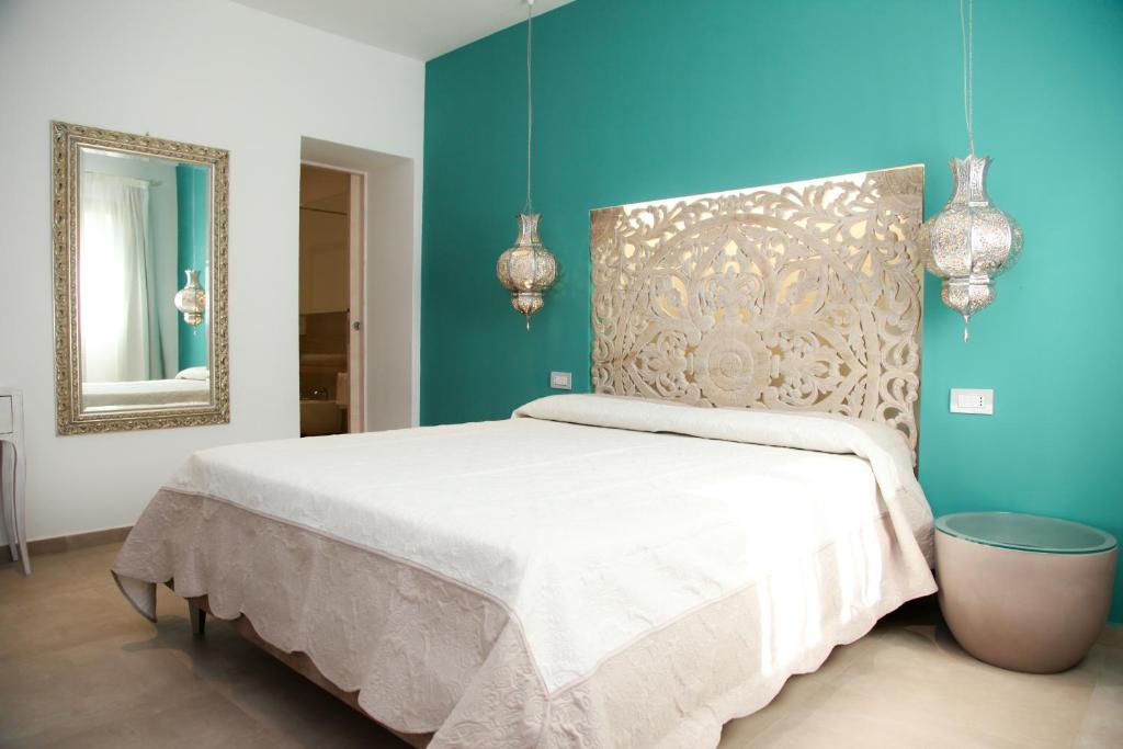 圣特奥多罗Hypnos Boutique Hotel的卧室配有白色的床和镜子