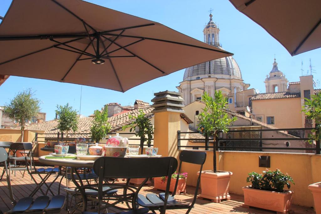 罗马纳沃那魅力住宿加早餐旅馆的庭院配有桌椅和遮阳伞。
